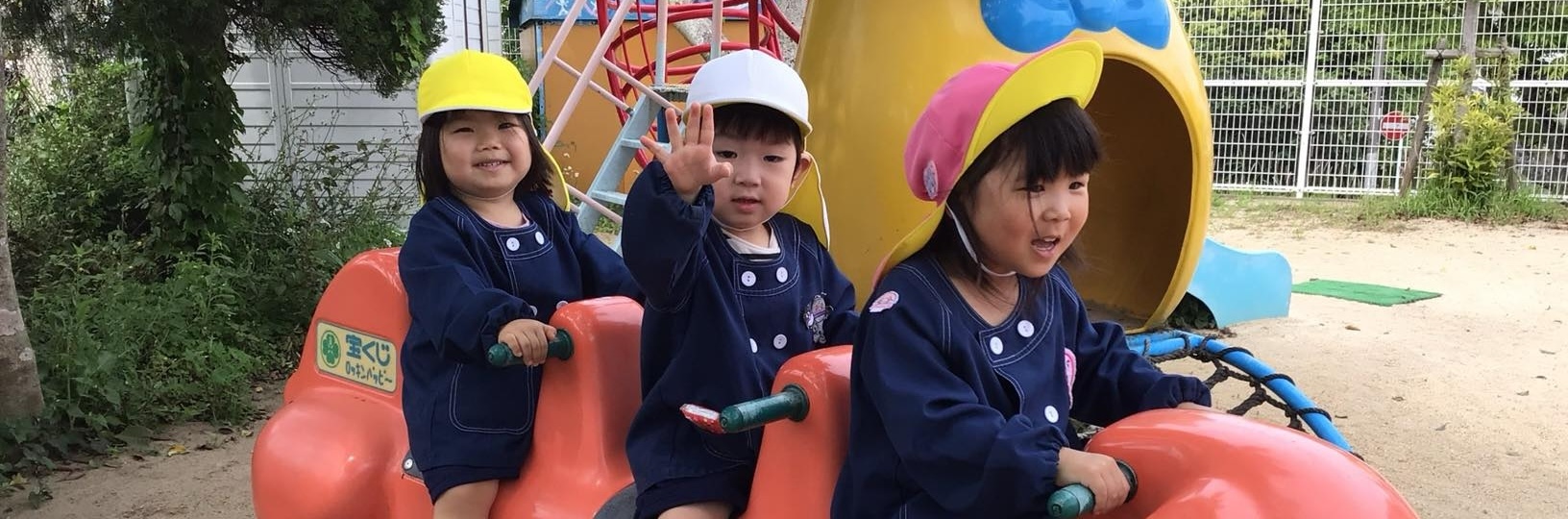 幼稚園の門の前で笑顔の園児